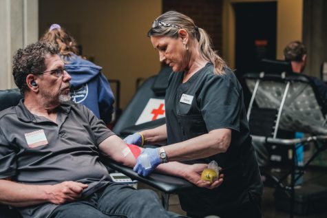American Red Cross nurse bandages the arm of a blood donor.