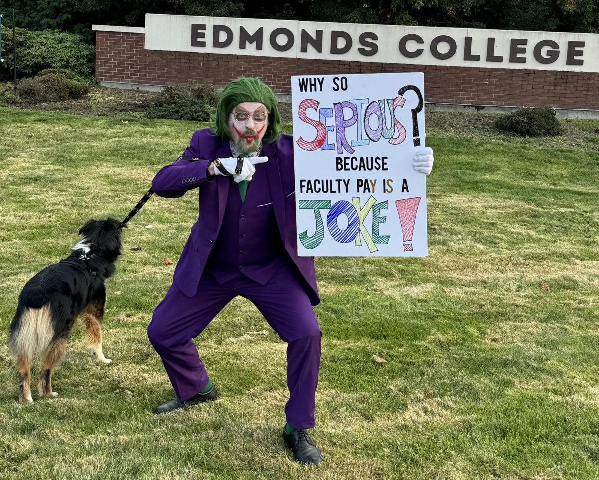 An costumed Edmonds faculty member pickets at the college entrance during a Halloween informational picketing session.